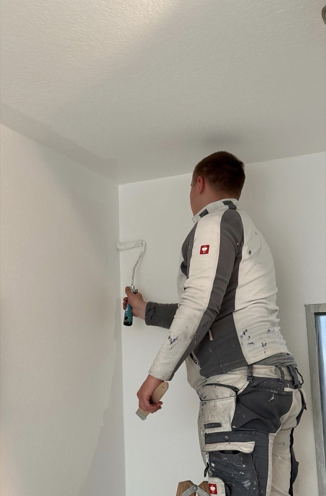 Maler von PR Raumdesign beim Innenanstrich mit der Rolle